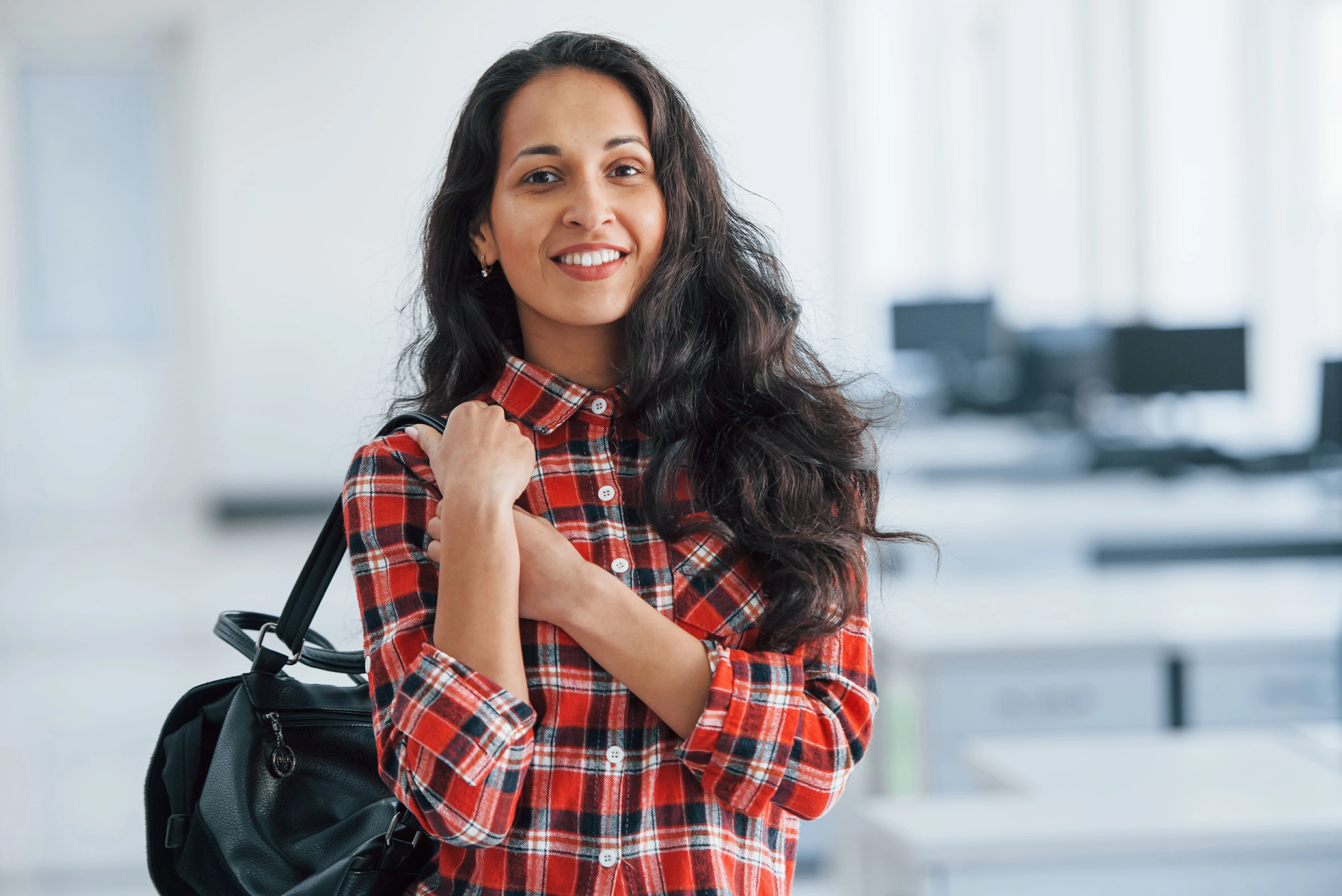 Portrait Of Smiling Male College Student In Busy Communal Campus Building